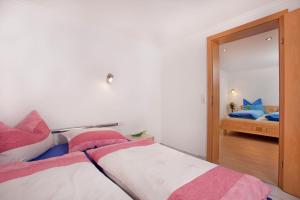 平茨高谷地霍勒尔斯巴赫霍切威姆度假别墅的一间卧室配有一张粉色和白色床单。