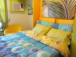宿务Nica's Place Property Management Services at Horizons 101 Condominium的一张带五颜六色的被子的床