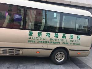 上海麦新格精品酒店川沙店的一辆白色的货车,车身边写字