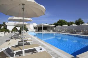 维耶斯泰里帕花园酒店的一座带椅子和遮阳伞的游泳池位于一座建筑旁边
