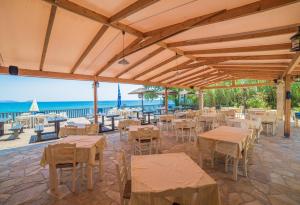 利萨基亚Porto Koukla Beach的一间设有桌椅的海洋餐厅