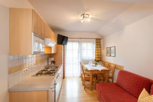 拉德施塔特纳斯内古特假日酒店的厨房以及带桌子和沙发的用餐室。