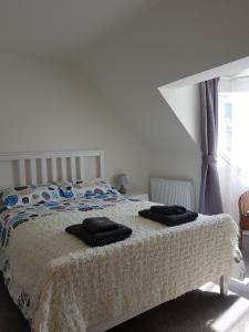 斯托诺韦Stornoway Lido flats的一间卧室配有一张床,上面有两条毛巾