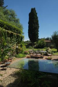 佛罗伦萨巴黎科比内里旅馆的一个带桌椅的花园和一个游泳池