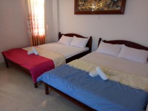惹岛Khách Sạn Hoàng Thông Lý Sơn的两张睡床彼此相邻,位于一个房间里