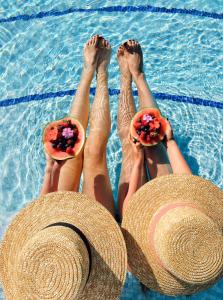 加尔达湖滨Villa Nicolli Romantic Resort - Adults Only的一群人躺在带帽子的游泳池里