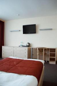 KlintsyUyut Centralnaya Hotel的卧室配有一张床,墙上配有电视。