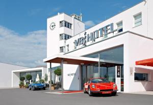 伯布林根经典摩托世界地区斯图加特V8酒店的停在白色建筑前的红色汽车