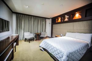 仁川市Incheon Airport Hotel Zeumes的酒店客房带一张床、一张桌子和椅子