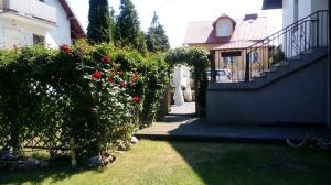 斯蒂格纳Biały Domek的一座房子,有楼梯和玫瑰庭院