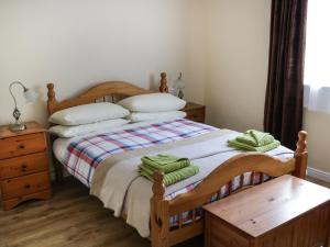 伦维尔Killary Bay View House的一间卧室配有一张带绿毛巾的床