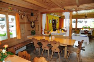 圣安特尼恩Berggasthaus Gemsli的一间带木桌和椅子的用餐室