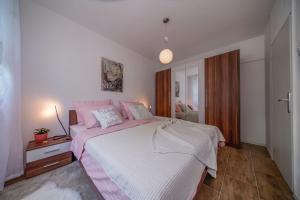 瓦拉日丁Apartment Happy Day的卧室配有一张带粉红色枕头的大床