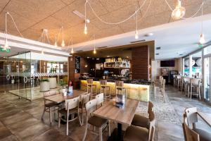 拉赫Apartamentos VIDA Mar de Laxe的一间带桌椅的餐厅和一间酒吧