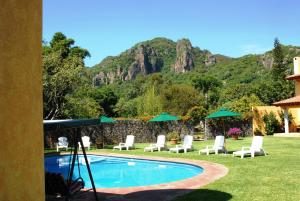 迪坡斯特兰迪坡斯特兰城拉斯卡西塔斯酒店的山前带椅子和遮阳伞的游泳池