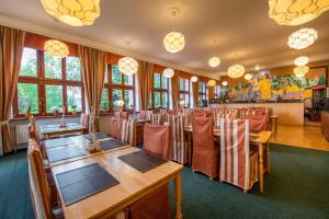Vysoke Tatry - Horny SmokovecMiramonti Penzión的餐厅设有木桌、椅子和窗户。