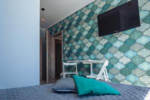 卢克钦Na Leniwych Wodach的一间卧室设有一台平面电视和绿色墙壁