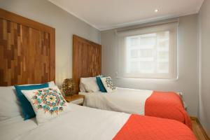 圣地亚哥Casa Bellavista Hotel的一间卧室设有两张床和窗户。