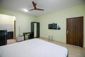 科尔瓦Sunshine Park Homes的一间卧室配有一张床和吊扇