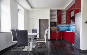 奥古斯图Blue Door Apartment Ground Floor的厨房配有红色橱柜和白色的桌椅