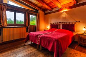 切萨纳·都灵尼斯Agriturismo il Fiocco的一间卧室设有红色的床和窗户。