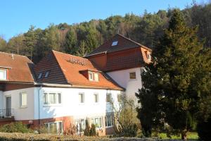 奥特贝格巴德司徒贝酒店的白色的建筑,带有棕色的屋顶