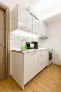 雅典Raise cosy apartment的白色的厨房配有白色橱柜和水槽
