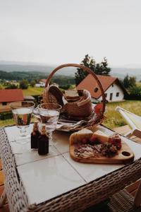 斯洛文尼亚比斯特里察Panorama Glamping Visole的野餐桌,带一篮子食物和眼镜
