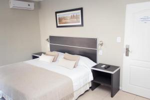 费德拉西翁Costa Del Sol的一间卧室配有一张大床和黑色床头板