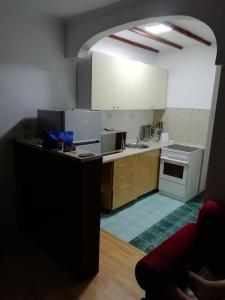 布德瓦apartman holiday budva的厨房配有白色橱柜和炉灶烤箱。