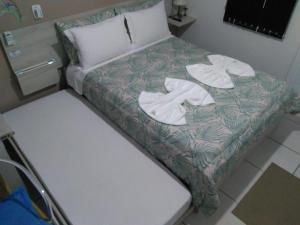 格拉玛多Hospedagem Da Laranjeira Gramado的房间里的一张床位,上面有两条毛巾