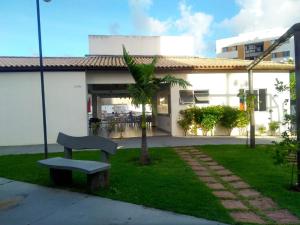 阿拉卡茹Condominio Port. da cidade Aracaju的坐在建筑物前面的草上的一个长凳