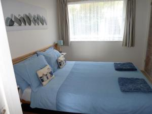 Bishopston2A Redcliffe Apartment的一间卧室配有蓝色的床、枕头和窗户