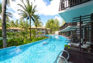 蔻立The Haven Khao Lak - SHA Extra Plus的棕榈树度假村的游泳池