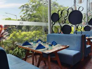 雅加达雅加达斯玛图庞美居酒店的一张桌子、两把蓝色的椅子和一张木桌