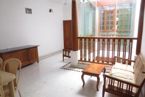 蓬蒂切里Maison Petite Singapore的一间带桌椅的客厅和一个阳台