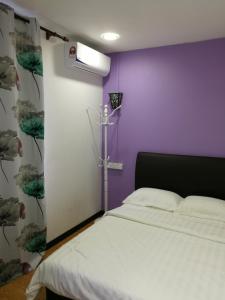 仙本那珊瑚之家民宿的卧室配有白色的床和紫色墙壁