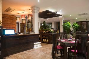 彭世洛Shinnabhura Historic Boutique Hotel的一间带桌子和酒吧的用餐室