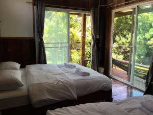 清刊班苏安拉月亮旅馆的带大窗户的客房内的两张床