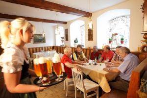 穆赫克雷斯的艾根Bärnsteinhof - Gasthof mit Herz的一群人坐在桌子上,喝啤酒