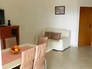 马林斯卡Apartmani Lucija Jurković的客厅配有沙发和带一碗水果的桌子