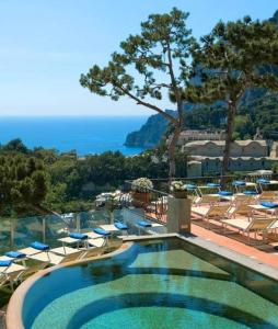 卡普里卡萨莫格诺酒店的一个带椅子的游泳池,享有海景