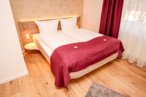赫曼斯堡Hotel Ohlendorfs Gasthaus的一间卧室配有一张带红色毯子的大床