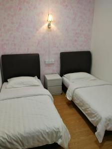 仙本那珊瑚之家民宿的配有粉红色壁纸的客房内的两张床