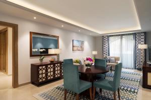 多哈Al Najada Doha Hotel Apartments by Oaks的客厅设有餐桌和椅子