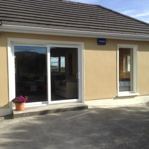 BallaghnatrillickBen Haven Self Catering Accommodation的一座带推拉玻璃门的建筑,设有窗户