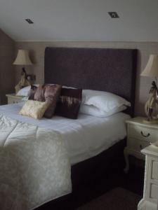 布什米尔斯Causeway Lodge的卧室配有带枕头的大型白色床