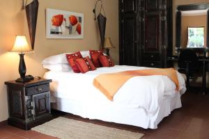 LephalaleMicasa Sucasa Guesthouse的一间卧室配有带白色床单和红色枕头的床。