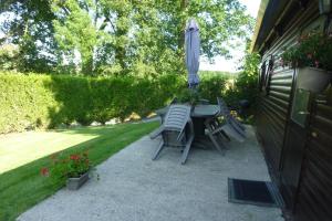 Pertheville-NersRelais Du Saussay的庭院内桌椅和遮阳伞