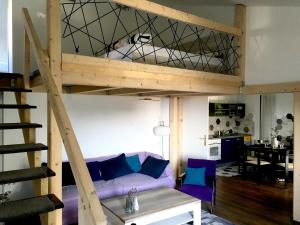 马林斯卡Apartment Olive Groove的客厅配有一张高架床和一张紫色沙发